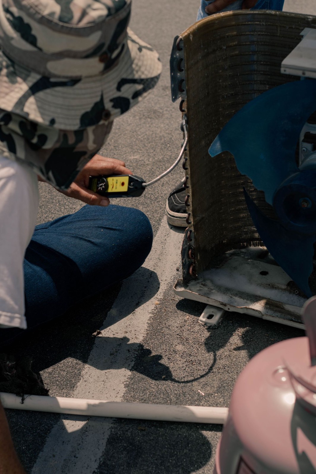 A technician servicing an outdoor air conditioning unit.