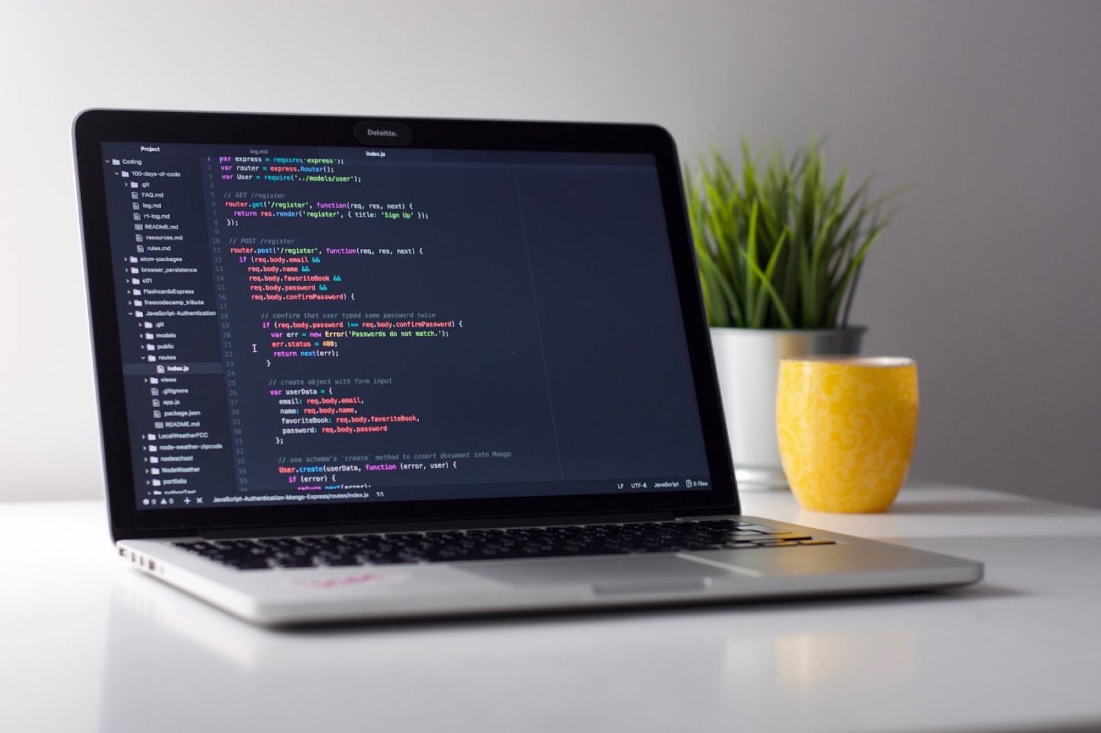 A laptop showing colorful code in a workspace.