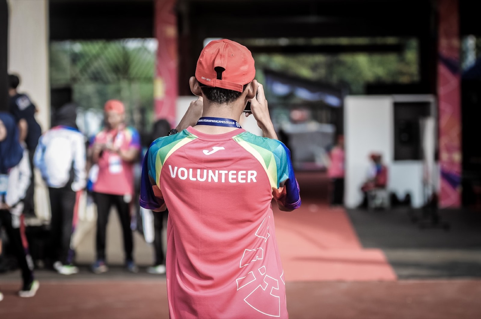 A volunteer in a marked shirt photographing a community event.