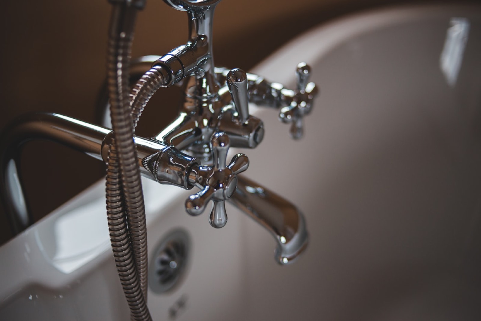 A chrome bathtub faucet on a white tub.