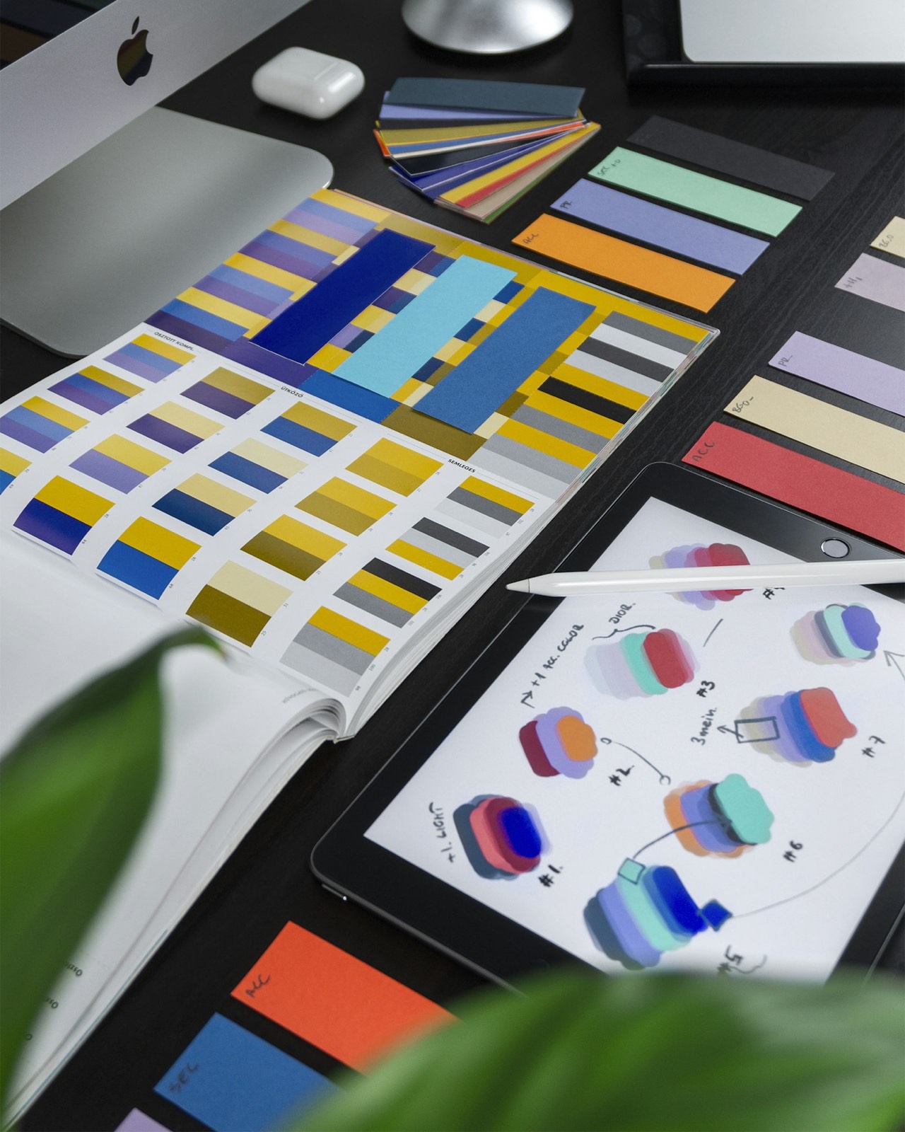 Color swatches and a tablet on a design desk.