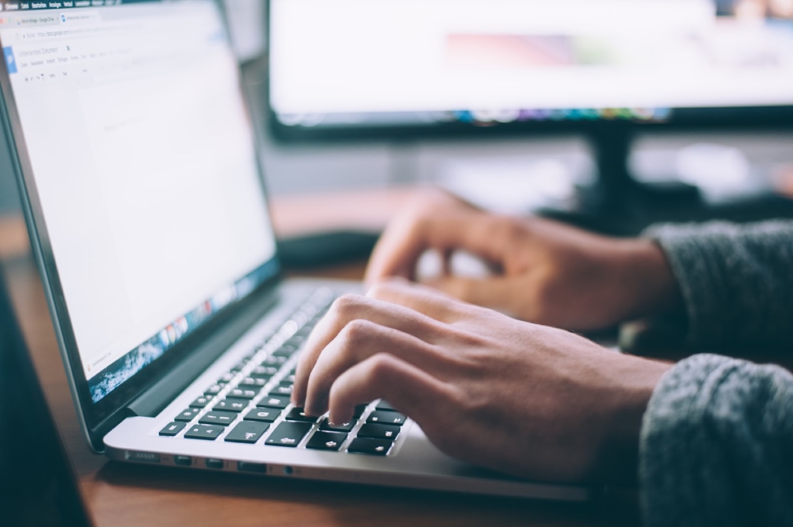 Someone typing on a laptop at a desk.